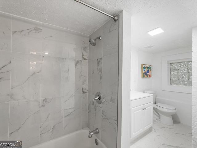 full bathroom featuring vanity, tiled shower / bath, toilet, and a textured ceiling