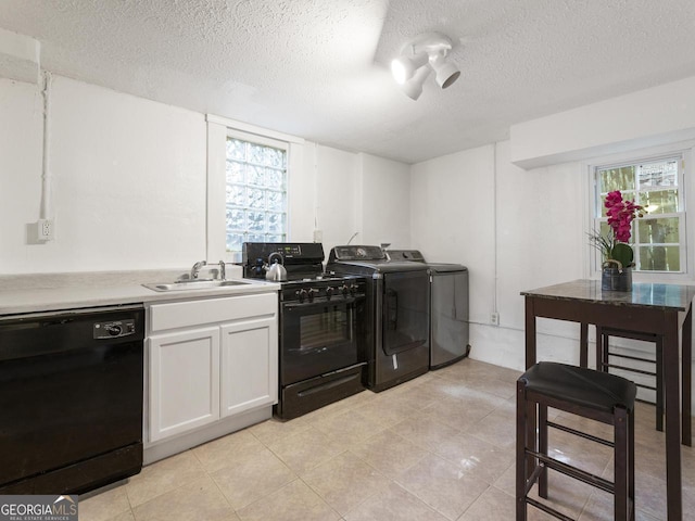 kitchen featuring white cabinetry, separate washer and dryer, sink, black appliances, and a textured ceiling