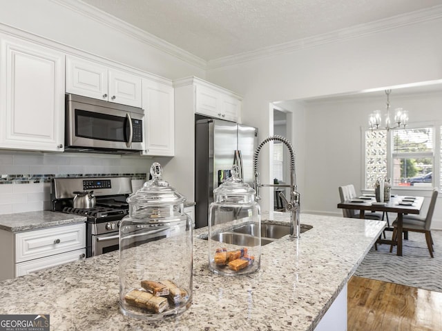 kitchen featuring white cabinetry, stainless steel appliances, light stone countertops, and a textured ceiling