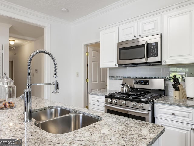 kitchen with sink, white cabinetry, crown molding, tasteful backsplash, and appliances with stainless steel finishes