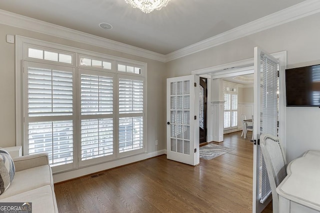 doorway to outside with ornamental molding, dark hardwood / wood-style floors, and an inviting chandelier