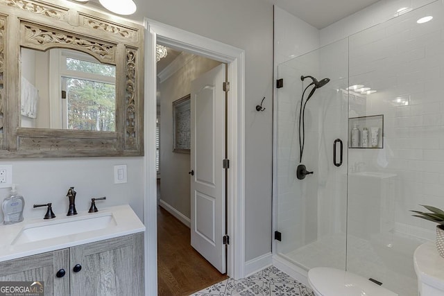 bathroom featuring toilet, hardwood / wood-style floors, vanity, and a shower with shower door