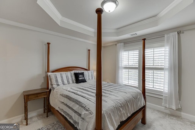 bedroom with crown molding, carpet, and a tray ceiling