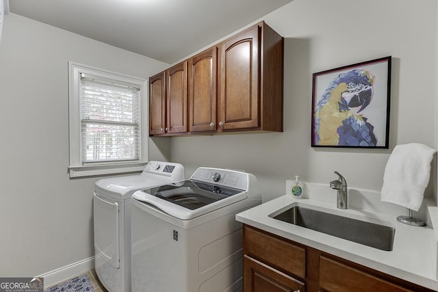 washroom featuring sink, cabinets, and independent washer and dryer