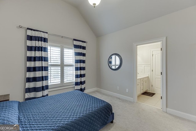 carpeted bedroom featuring ensuite bathroom and lofted ceiling