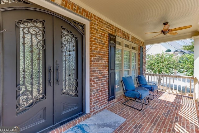 entrance to property featuring french doors, ceiling fan, and a porch