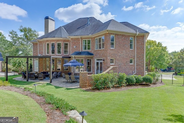 rear view of property with a yard and a patio area