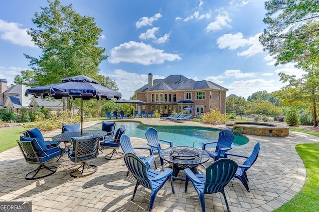 view of pool with an in ground hot tub, a fire pit, and a patio area