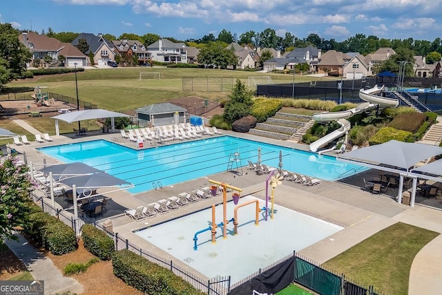 view of pool featuring a water slide, a yard, and a patio area