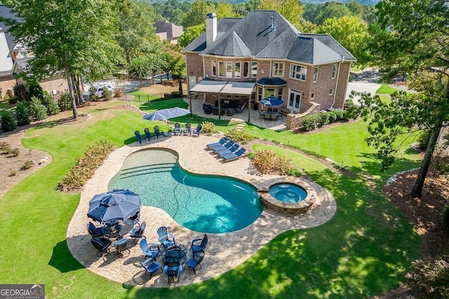 back of house featuring a pool with hot tub, a patio area, and a lawn