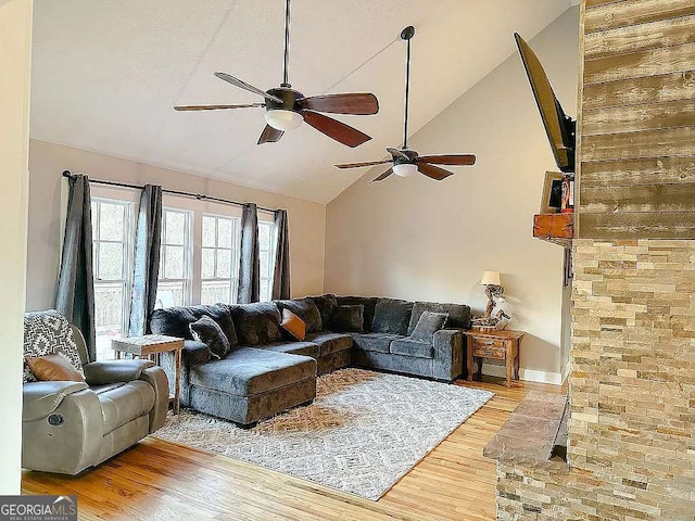 living room featuring ceiling fan, hardwood / wood-style floors, and high vaulted ceiling