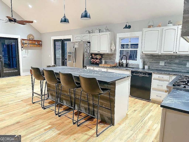 1150 Sutton Rd, Demorest, GA 30535 - kitchen with black dishwasher, a sink, stainless steel fridge, dark countertops, and decorative backsplash