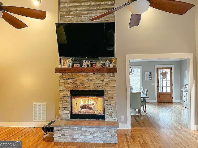 unfurnished living room with ceiling fan, a fireplace, and hardwood / wood-style floors