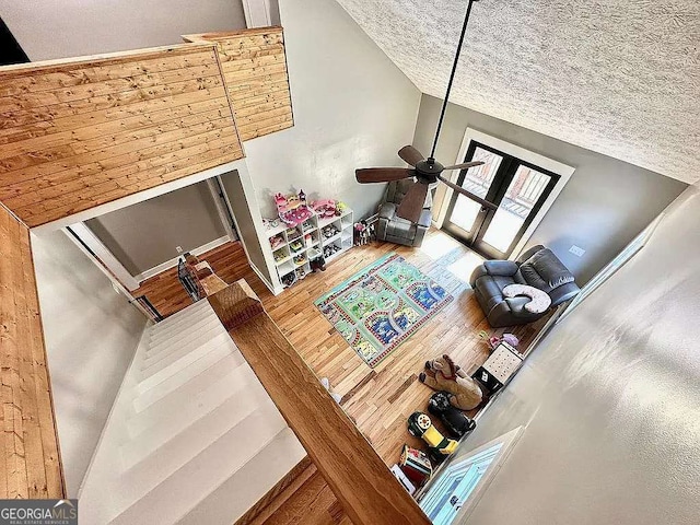 living room featuring a towering ceiling and ceiling fan