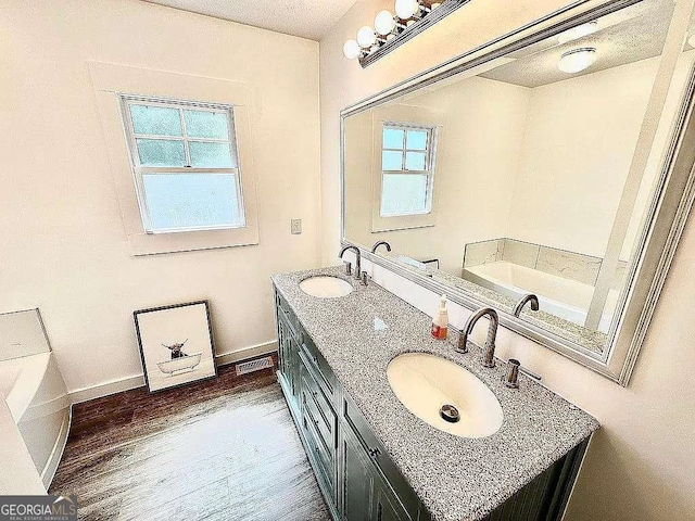 1150 Sutton Rd, Demorest, GA 30535 - bathroom with double vanity, a garden tub, baseboards, and wood finished floors
