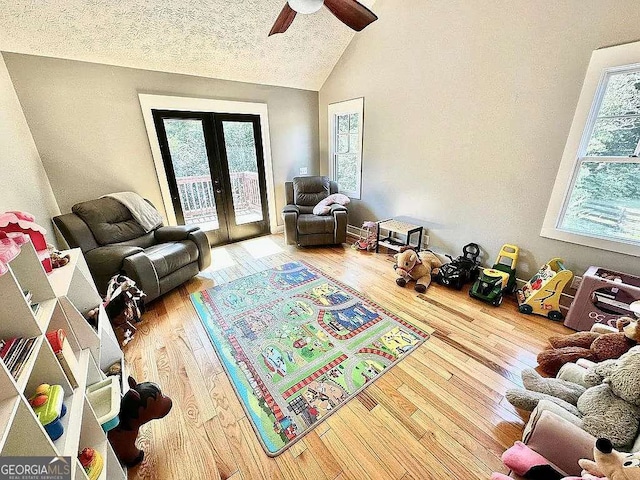 1150 Sutton Rd, Demorest, GA 30535 - living room featuring lofted ceiling, french doors, wood finished floors, ceiling fan, and a textured ceiling