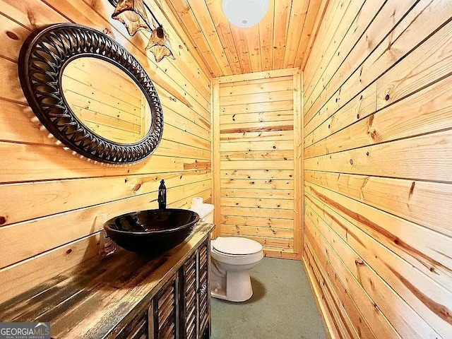 bathroom featuring vanity, wooden ceiling, wooden walls, and toilet