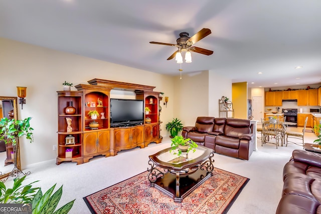 carpeted living room with ceiling fan