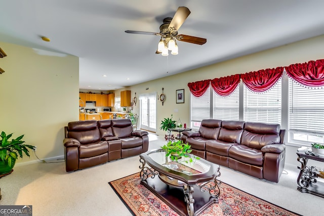 living room with ceiling fan, plenty of natural light, and carpet flooring