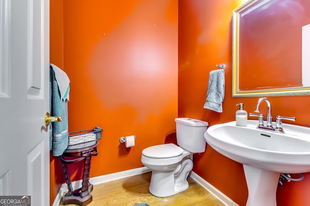 bathroom featuring sink, hardwood / wood-style flooring, and toilet