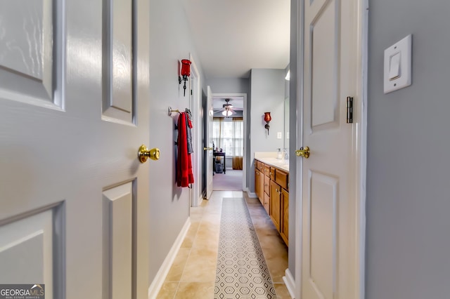 corridor with sink and light tile patterned floors