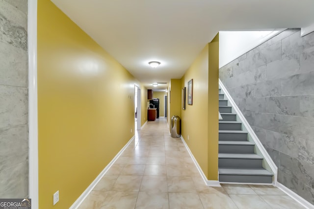 corridor featuring tile walls and light tile patterned floors