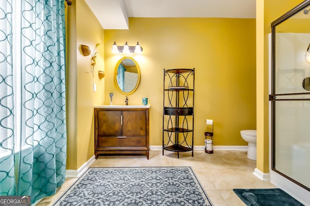 bathroom featuring toilet, vanity, tile patterned floors, and walk in shower