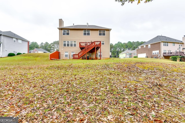 rear view of house with a deck and a lawn