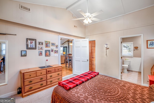 carpeted bedroom featuring lofted ceiling with beams, a closet, ceiling fan, and ensuite bathroom