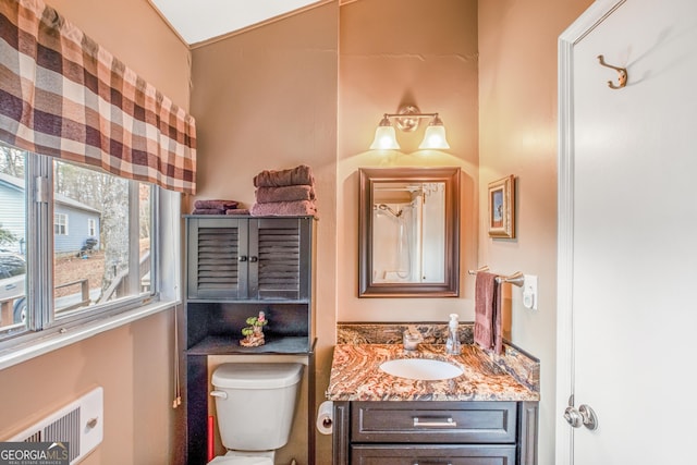 bathroom featuring vanity, radiator heating unit, and toilet