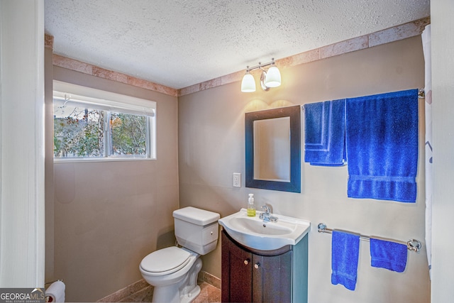 bathroom featuring vanity, toilet, and a textured ceiling