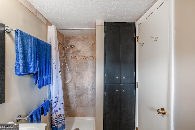 bathroom featuring curtained shower and a textured ceiling