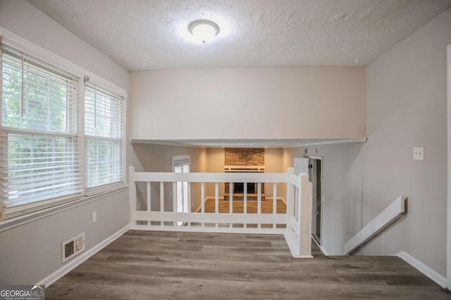 staircase with hardwood / wood-style floors and a textured ceiling