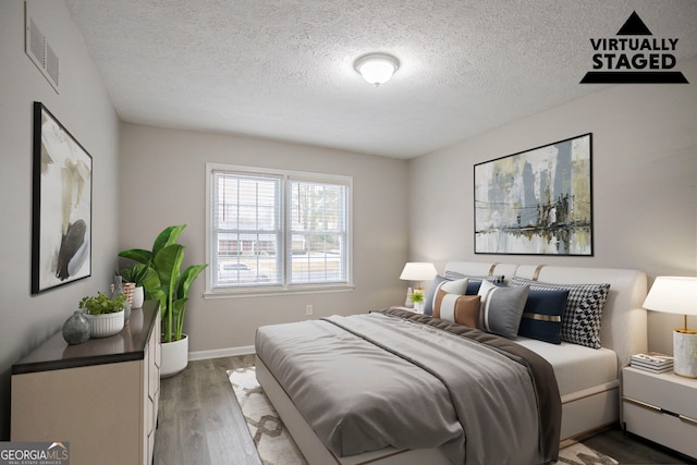 bedroom with wood-type flooring and a textured ceiling