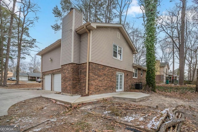 view of side of home with central AC and a garage