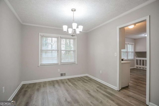 empty room featuring plenty of natural light, hardwood / wood-style floors, and a textured ceiling