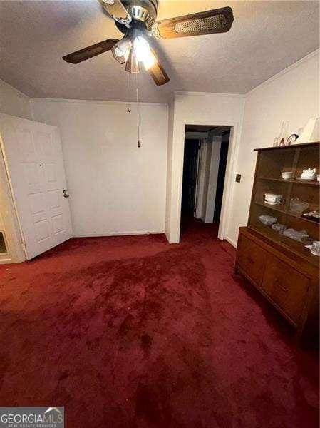 bedroom featuring a textured ceiling, ceiling fan, and dark colored carpet