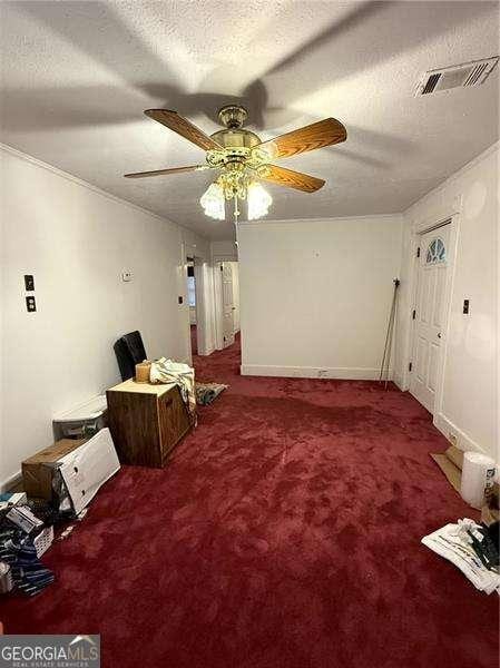 interior space featuring ceiling fan and a textured ceiling