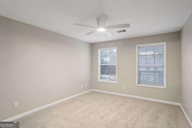 carpeted spare room with ceiling fan