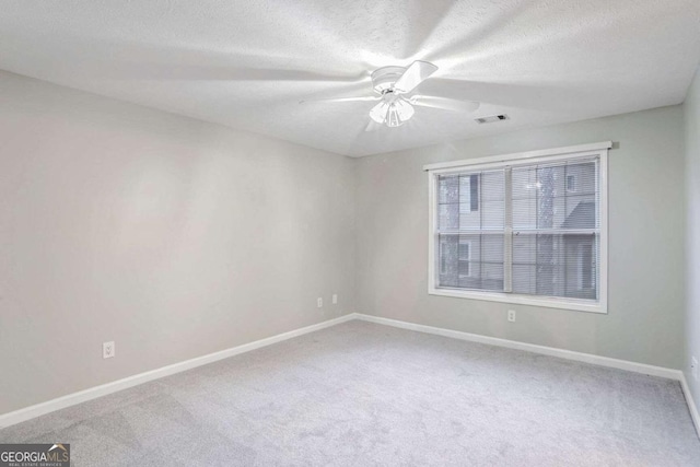 carpeted spare room featuring a textured ceiling and ceiling fan