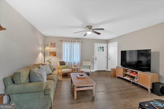 living room with ceiling fan and dark hardwood / wood-style flooring