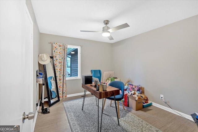 home office with light hardwood / wood-style flooring and ceiling fan