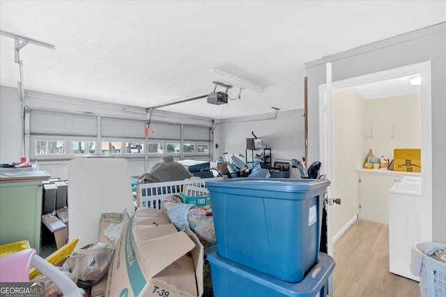 garage featuring a garage door opener and washer / dryer