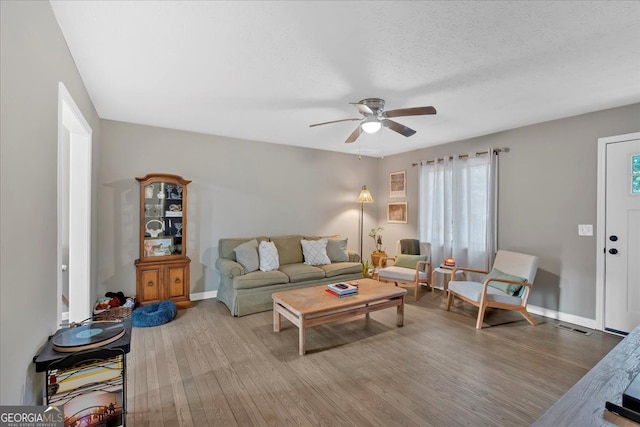 living room featuring hardwood / wood-style flooring, ceiling fan, a healthy amount of sunlight, and a textured ceiling