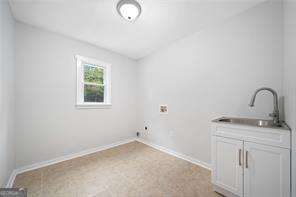 washroom with sink, cabinets, and hookup for a washing machine