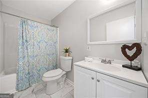 full bathroom featuring toilet, shower / bathtub combination with curtain, and vanity