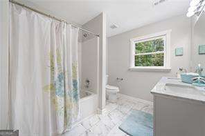 full bathroom with vanity, toilet, and shower / bath combo with shower curtain