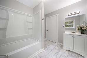 bathroom featuring shower / tub combination and vanity