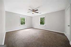 carpeted empty room featuring ceiling fan