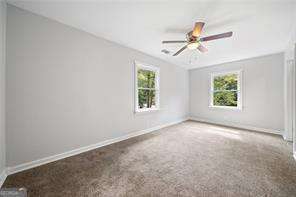 carpeted spare room with ceiling fan